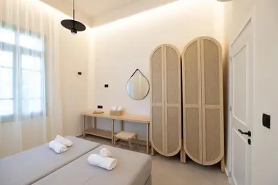a room with two beds and a dressing table at Casa Alini in Ialyssos