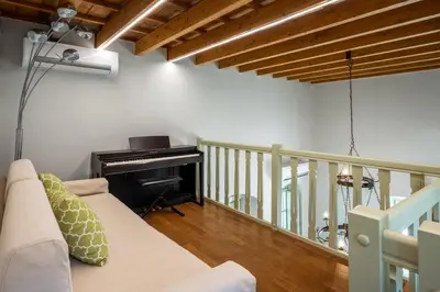 a living room with a couch and a piano at Siliguri Traditional House in Rhodes Town