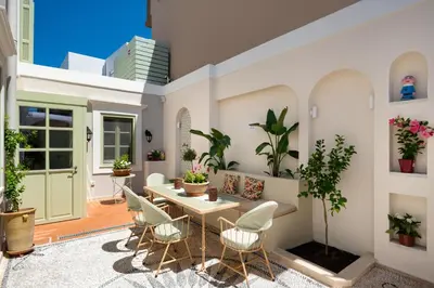 a patio with a table and chairs and plants at Siliguri Traditional House in Rhodes Town
