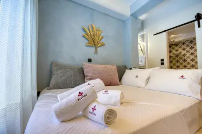 a bedroom with a large white bed with towels on it at Bastion Luxury Medieval Accommodation in Rhodes Town