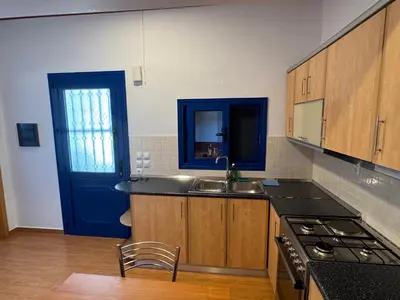 a kitchen with a sink and a blue door at PARADISE SEA HOUSE a in Haraki