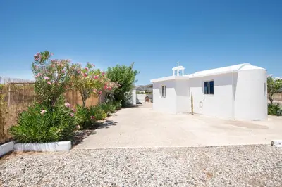 a small white building with a fence and flowers at PARADISE SEA HOUSE a in Haraki