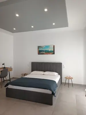 a bedroom with a bed and a desk at Platanou 21 Apartments in Kremasti