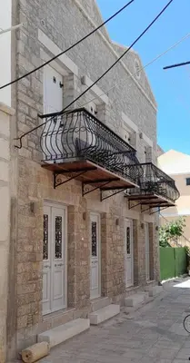 a brick building with a metal fire escape on it at Charistella Apartment in Symi