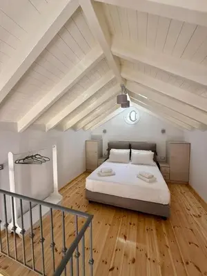 a bedroom with a large bed in an attic at Charistella Apartment in Symi