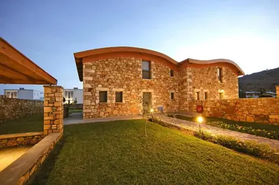 a large brick building with a yard in front of it at Semi-detached house with private pool in Lardos
