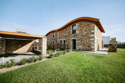 a brick house with an archway on a lawn at Semi-detached house with private pool in Lardos