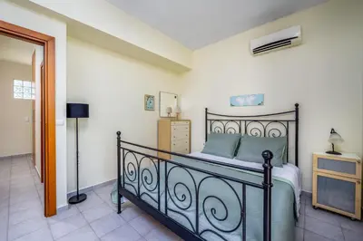 a bedroom with a bed and a dresser in it at Euphoria Villa up to 5 in Ialyssos
