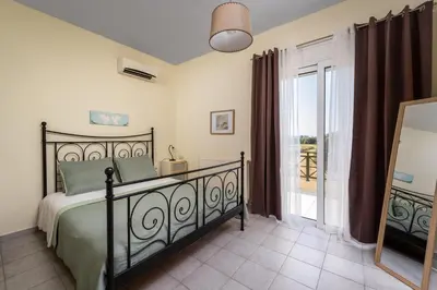 a bedroom with a bed and a sliding glass door at Euphoria Villa up to 5 in Ialyssos