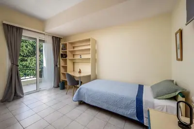 a bedroom with a bed and a desk and a window at Euphoria Villa up to 5 in Ialyssos