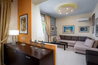 a living room with a couch and a table at Euphoria Villa up to 5 in Ialyssos