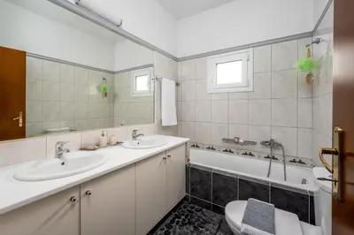 a bathroom with two sinks and a tub and a toilet at Euphoria Villa up to 5 in Ialyssos