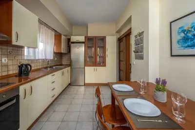 a kitchen with a wooden table with chairs and a tableasteryasteryasteryasteryastery at Euphoria Villa up to 5 in Ialyssos