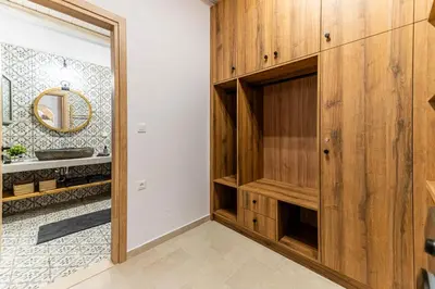 a bathroom with wooden cabinets and a mirror at Filoxenia House in Archangelos