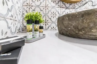 three bottles of essential oils sitting on a counter with a plant at Filoxenia House in Archangelos
