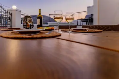 a table with two glasses of white wine on it at Filoxenia House in Archangelos