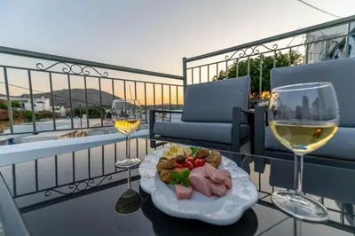 a plate of food on a table with wine glasses at Filoxenia House in Archangelos