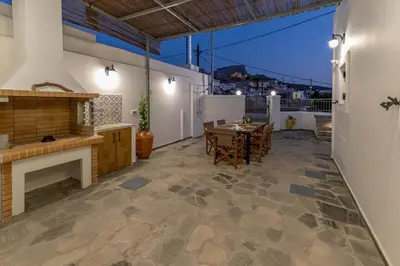 a living room with a table and a fireplace at Filoxenia House in Archangelos