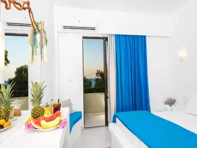 a bedroom with a bed and a table with fruit on it at Mojito Beach Rooms in Lachania