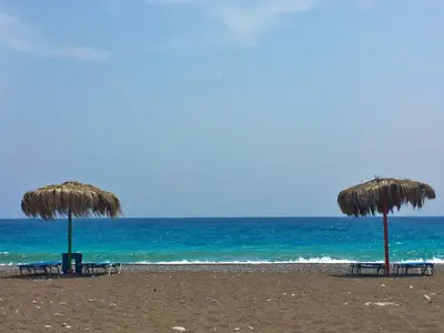two chairs and umbrellas on a beach with the ocean at Mojito Beach Rooms in Lachania