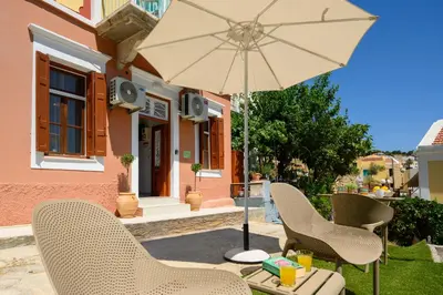 a patio with two chairs and an umbrella at Pissadi House in Symi