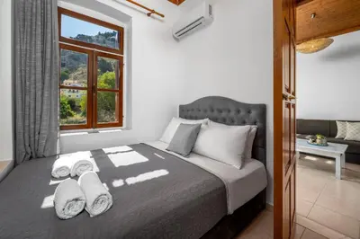 a bedroom with a large bed with a window at Pissadi House in Symi