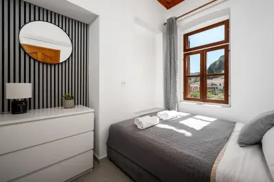 a bedroom with a bed and a dresser and a mirror at Pissadi House in Symi