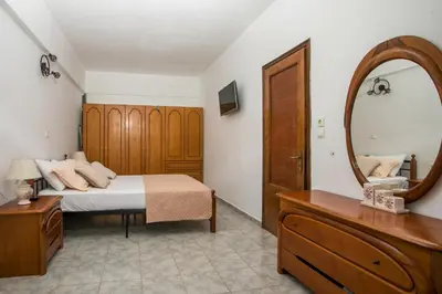 a bedroom with a bed and a mirror and a dresser at Dimitris studios & apartments in Faliraki