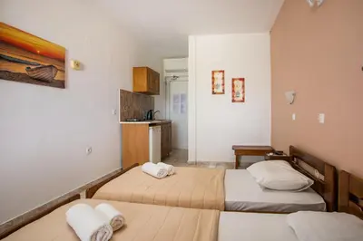 two beds in a small room with a kitchen at Dimitris studios & apartments in Faliraki