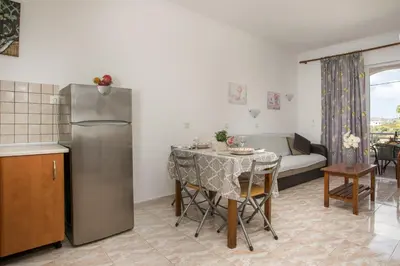 a kitchen and living room with a table and a refrigerator at Dimitris studios & apartments in Faliraki