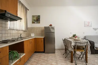 a small kitchen with a table and a refrigerator at Dimitris studios & apartments in Faliraki