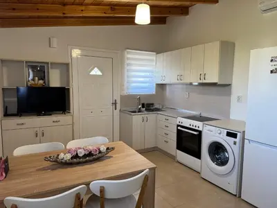 a kitchen with a table with a bowl of flowers on it at The Wooden Nest in Asgourou