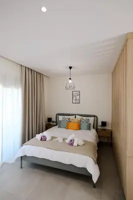 a bedroom with a bed with two stuffed animals on it at Olympian Apartments in Ialyssos