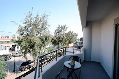 a balcony with a table and a view of a street at Olympian Apartments in Ialyssos