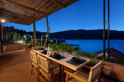 a table on a patio with a view of the water at Gama luxury living in Symi