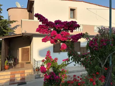 a house with pink flowers on the side of it at Casa Maria Tsampika-Spacious Home with 2 Bathrooms & Free Parking in Psinthos