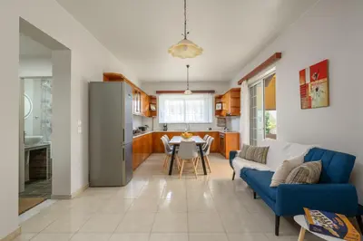 a living room with a blue couch and a table at Flora Beach House in Kremasti