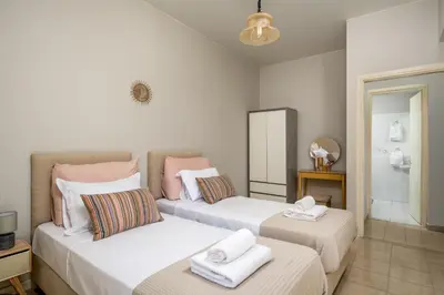 a bedroom with two beds with towels on them at Flora Beach House in Kremasti