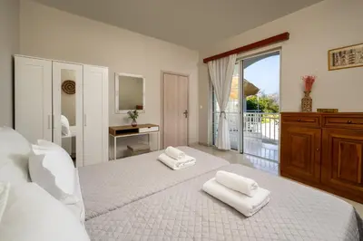 a bedroom with a large bed with two towels on it at Flora Beach House in Kremasti