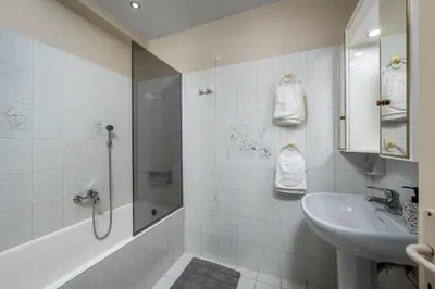 a white bathroom with a sink and a shower at Flora Beach House in Kremasti