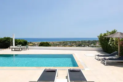 a swimming pool with a view of the ocean at Hill & Sea View White Pearl Villa in Afantou