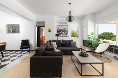 a living room with a couch and a table at Hill & Sea View White Pearl Villa in Afantou