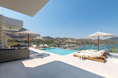 a villa with a swimming pool with a view at Blue Infinito Boutique Villa, Infinity Pool , Heated Jacuzzi & Panoramic Sea View in Archangelos