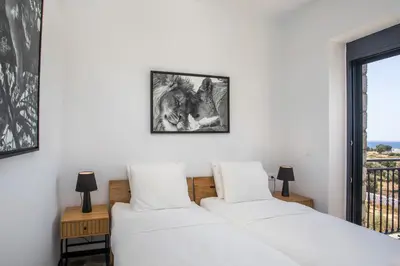 two beds in a bedroom with a window at Villa Clara in Gennadi
