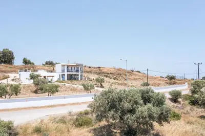 a road in the desert with a house in the background at Villa Clara in Gennadi