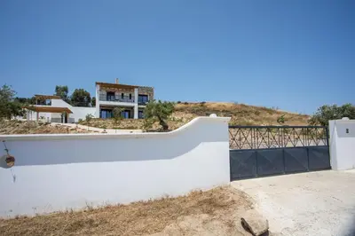 a white wall with a house in the background at Villa Clara in Gennadi