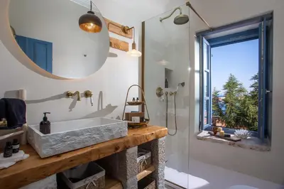 a bathroom with a sink and a mirror and a shower at Anteli Luxury Villa in Halki