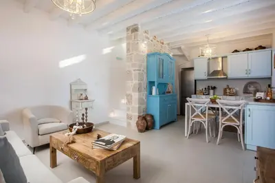 a kitchen and living room with blue cabinets and a table at Anteli Luxury Villa in Halki