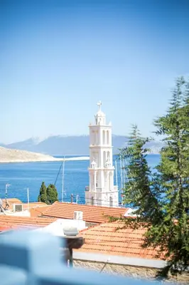 a white clock tower on top of a building at Anteli Luxury Villa in Halki