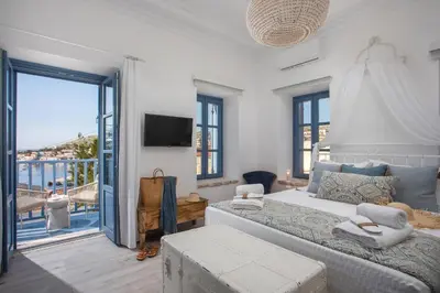 a bedroom with a large bed and a balcony at Anteli Luxury Villa in Halki
